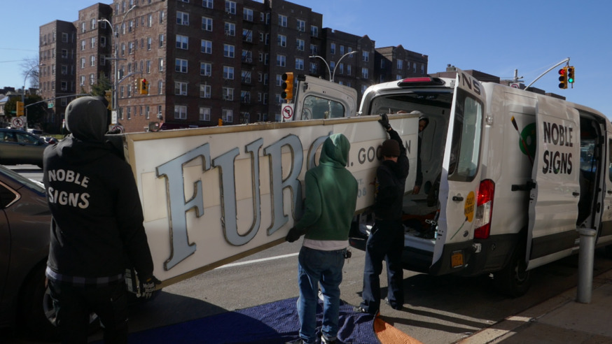 Placing the vintage sign into the Noble Signs vehicle, Photo by Michael Perlman