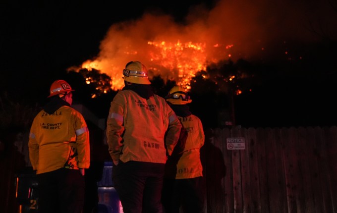 LOS ANGELES, US - JANUARY 10: Firefighters from the Los Angeles County Fire Department stand vigilant as they battle wildfires in Los Angeles while several blazes continue to tear through the region on January 10, 2025. The Palisades Fire, now the largest wildfire, has consumed nearly 20,000 acres, while the Kenneth Fire, which erupted Thursday afternoon, has quickly spread over 800 acres. As the death toll rises to 10, authorities continue their search for victims. The fires have destroyed thousands of homes and caused widespread damage across the city. (Photo by Lokman Vural Elibol/Anadolu via Getty Images)