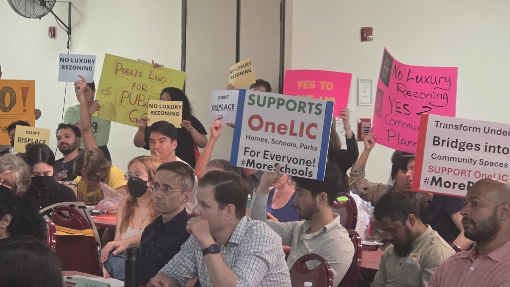 Supporters and opponents of the OneLIC Neighborhood Plan hold signs during Thursday's monthly Community Board 2 meeting. Photo: Shane O'Brien